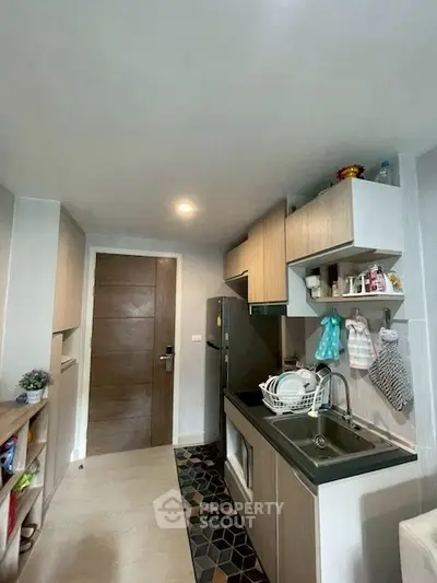 Modern kitchen with sleek cabinetry and stylish tile flooring in a cozy apartment.