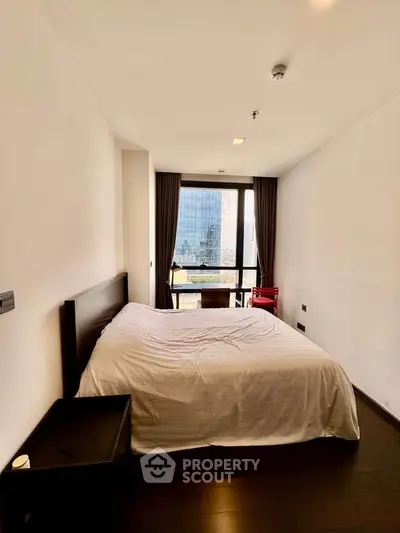 Spacious bedroom with city view, featuring a large bed and modern furnishings, ideal for urban living.