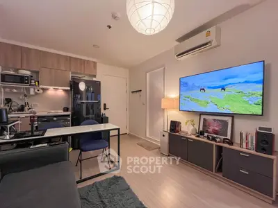 Modern living room with open kitchen, stylish decor, and wall-mounted TV