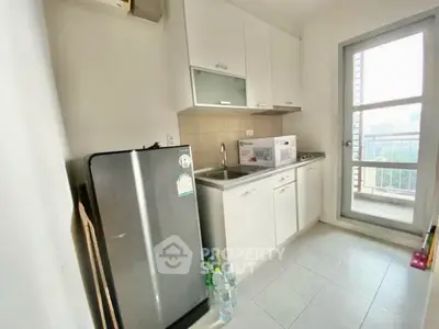Compact kitchen with modern appliances and balcony access