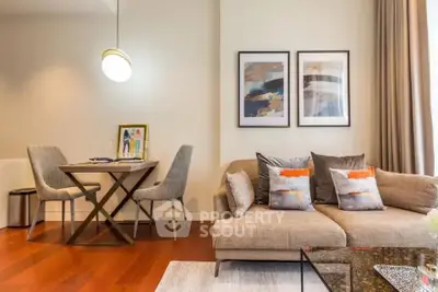 Modern living room with stylish decor and dining area, featuring elegant furniture and artwork.
