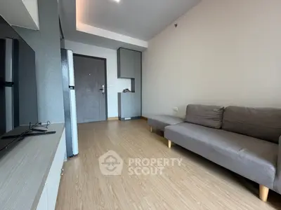 Modern living room with sleek grey sofa and wooden flooring
