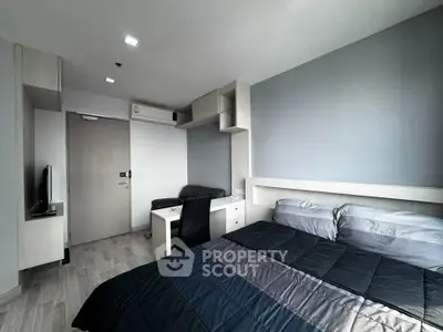 Modern bedroom with sleek furniture and neutral tones, featuring a cozy bed and compact workspace.