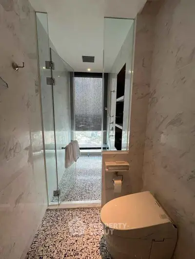 Luxurious bathroom with modern fixtures and a sleek glass shower enclosure.