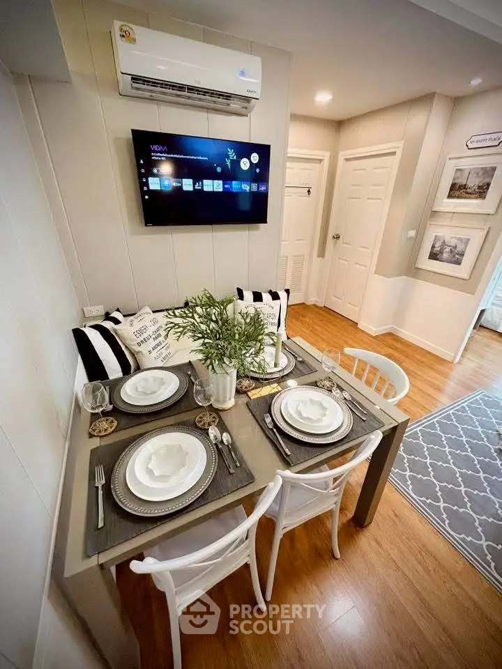 Charming dining area with modern decor and wall-mounted TV in cozy apartment setting.