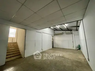 Spacious industrial-style storage room with high ceiling and concrete floor