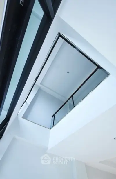 Modern architectural design with sleek glass and metal elements in a bright space.