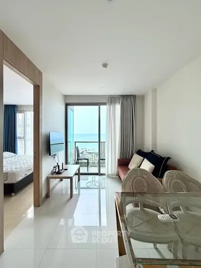Modern living room with ocean view, featuring sleek furniture and natural light.