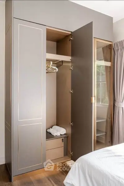 Elegant bedroom with open wardrobe showcasing modern design and ample storage space.
