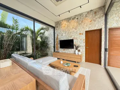Luxurious modern living room with stone wall, large windows, and stylish wooden furniture.
