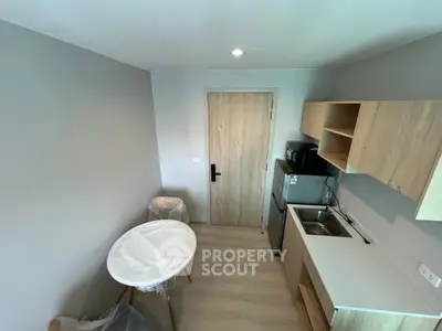 Modern compact kitchen with sleek wooden cabinets and stainless steel appliances