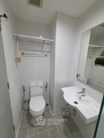 Modern bathroom with sleek fixtures and minimalist design, featuring a wall-mounted sink and toilet.