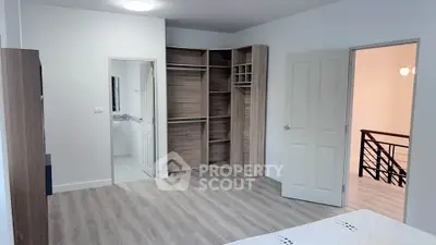 Spacious bedroom with modern closet and wooden flooring in a stylish home.