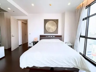 Luxurious bedroom with modern decor and large windows offering city views.