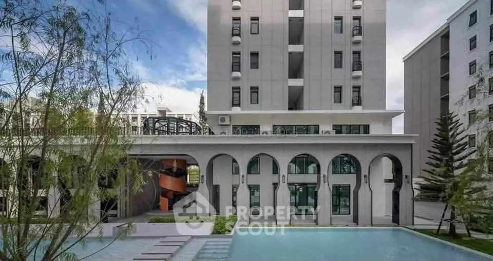 Modern apartment building with pool and lush landscaping
