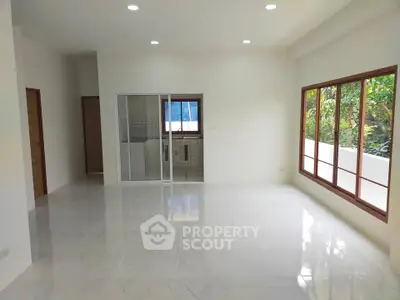 Spacious living room with large windows and natural light in modern home