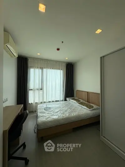 Modern bedroom with large window and minimalist design in a high-rise apartment.