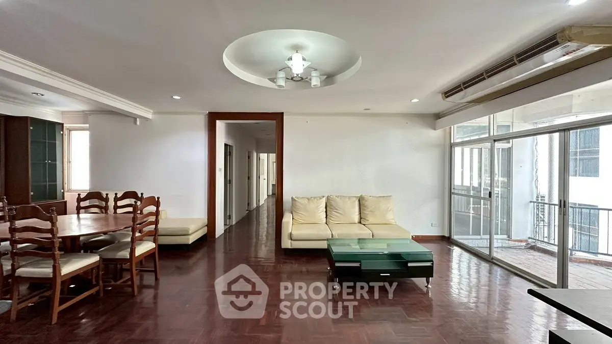 Spacious living room with elegant wooden flooring and modern furniture in a bright apartment.