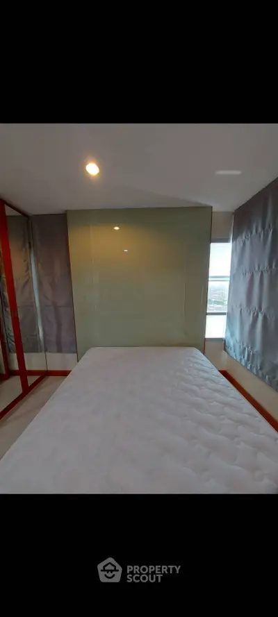 Modern bedroom with large window and minimalist design, featuring a comfortable bed and sleek glass wall.