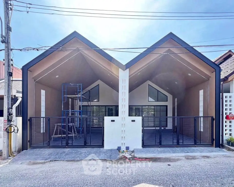 Modern twin houses with unique gable roofs and spacious front yards in a serene neighborhood.
