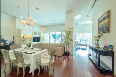 Luxurious open-plan living and dining area with elegant decor and city view.