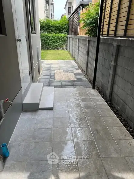 Modern outdoor patio with tiled flooring and lush greenery
