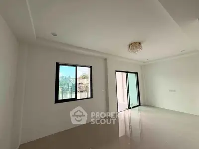 Spacious empty living room with large windows and modern chandelier