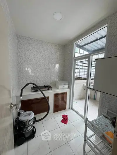 Compact kitchen with gas stove and modern appliances, featuring a bright window view.