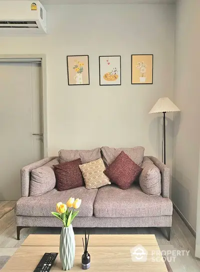 Cozy living room with stylish sofa, decorative pillows, and elegant wall art.