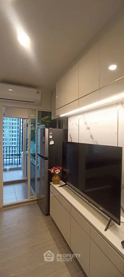 Modern living room with sleek TV setup and balcony view