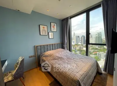 Modern bedroom with city view, featuring stylish decor and large windows for natural light.