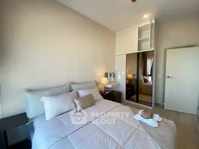 Modern bedroom with cozy bedding and mirrored wardrobe in stylish apartment