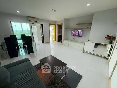 Spacious modern living room with sleek furniture and large windows offering natural light.