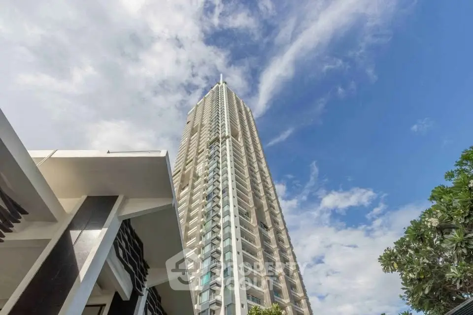 Stunning high-rise building with modern architecture against a clear blue sky, perfect for urban living.