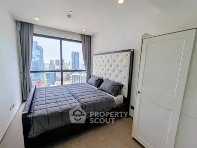 Luxurious bedroom with stunning city view and elegant decor in high-rise apartment.