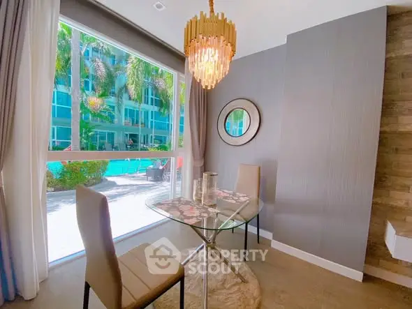 Elegant dining area with pool view, modern chandelier, and stylish decor.