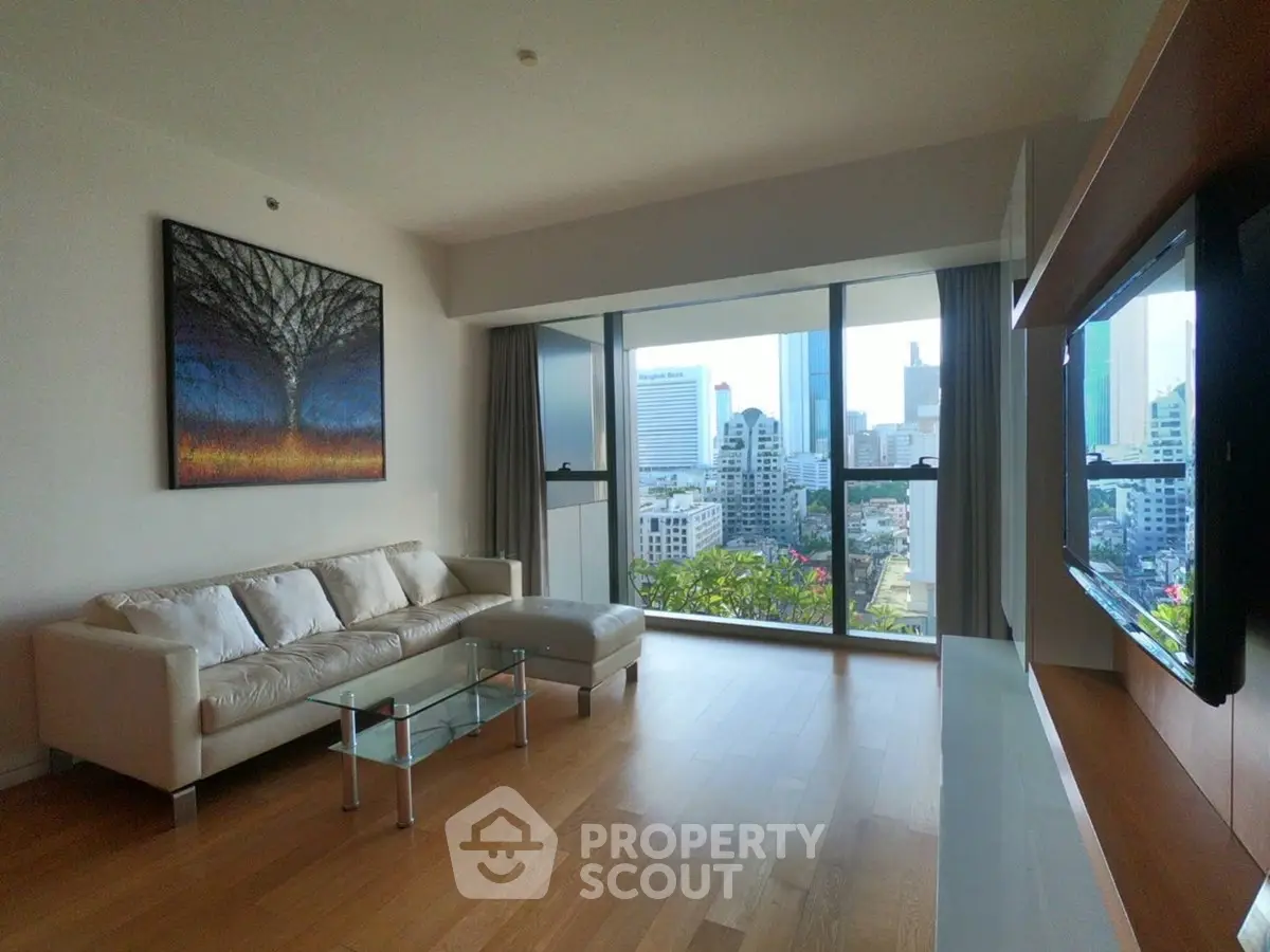 Spacious living room with city view and modern decor in high-rise apartment.