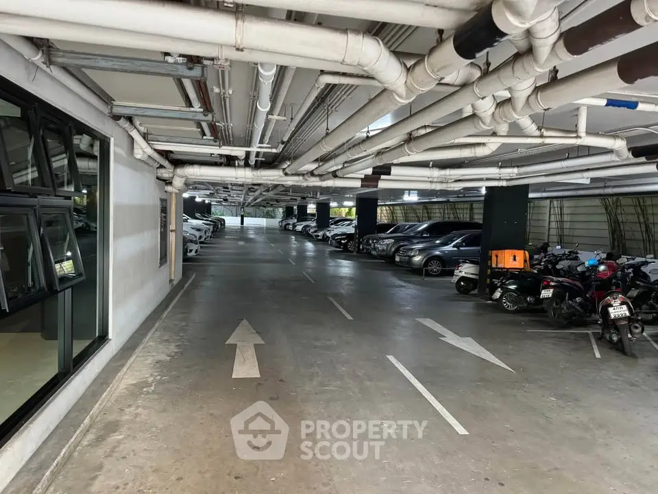 Spacious indoor parking area with ample lighting and clear directional markings.
