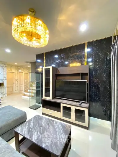 Luxurious living room with elegant chandelier and modern TV setup