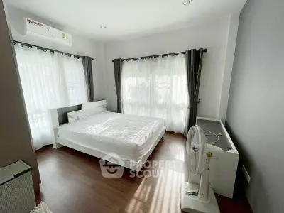 Bright and airy bedroom with modern furnishings and large windows.