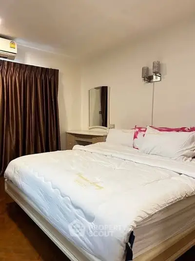 Cozy bedroom with elegant decor and plush bedding in a modern apartment.