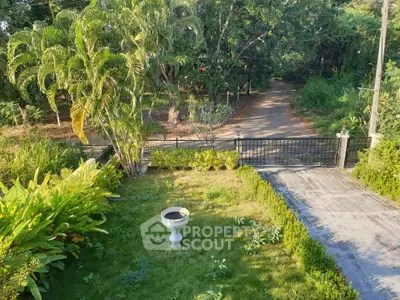 Charming garden view with lush greenery and gated entrance