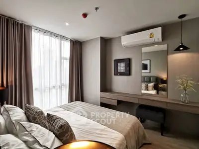 Modern bedroom with stylish decor, featuring a large window, air conditioning, and elegant furnishings.