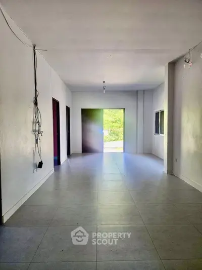 Spacious unfurnished room with large windows and tiled floor, ideal for customization.