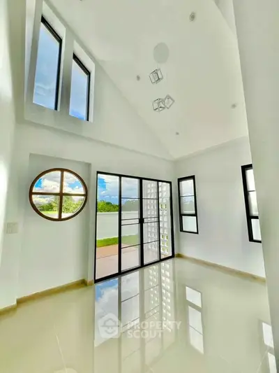 Stunning modern living room with high ceilings and large windows offering abundant natural light.