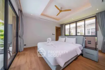 Luxurious bedroom with elegant decor and large windows offering natural light and garden view.