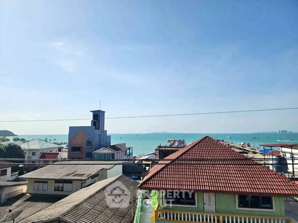 Stunning coastal view from a rooftop overlooking the ocean and nearby buildings, perfect for seaside living.