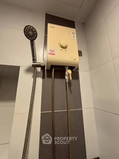 Modern bathroom with sleek shower and water heater, perfect for a cozy home.