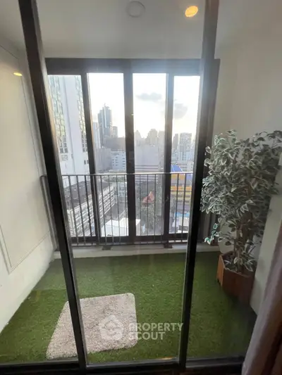 Charming balcony with artificial grass and stunning city view, perfect for relaxation.