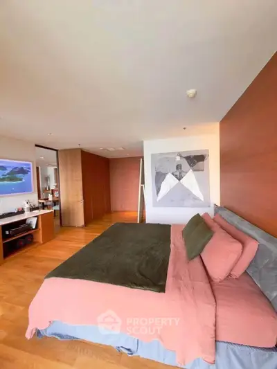 Spacious modern bedroom with wooden flooring and stylish decor